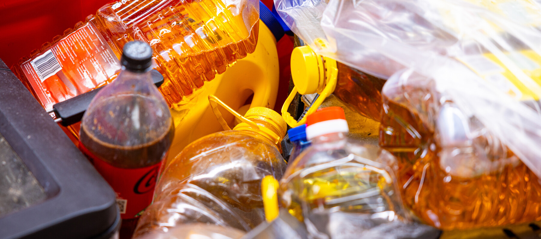 Flessen en flacons gebruikt frituurvet en frituurolie ingezameld in bak