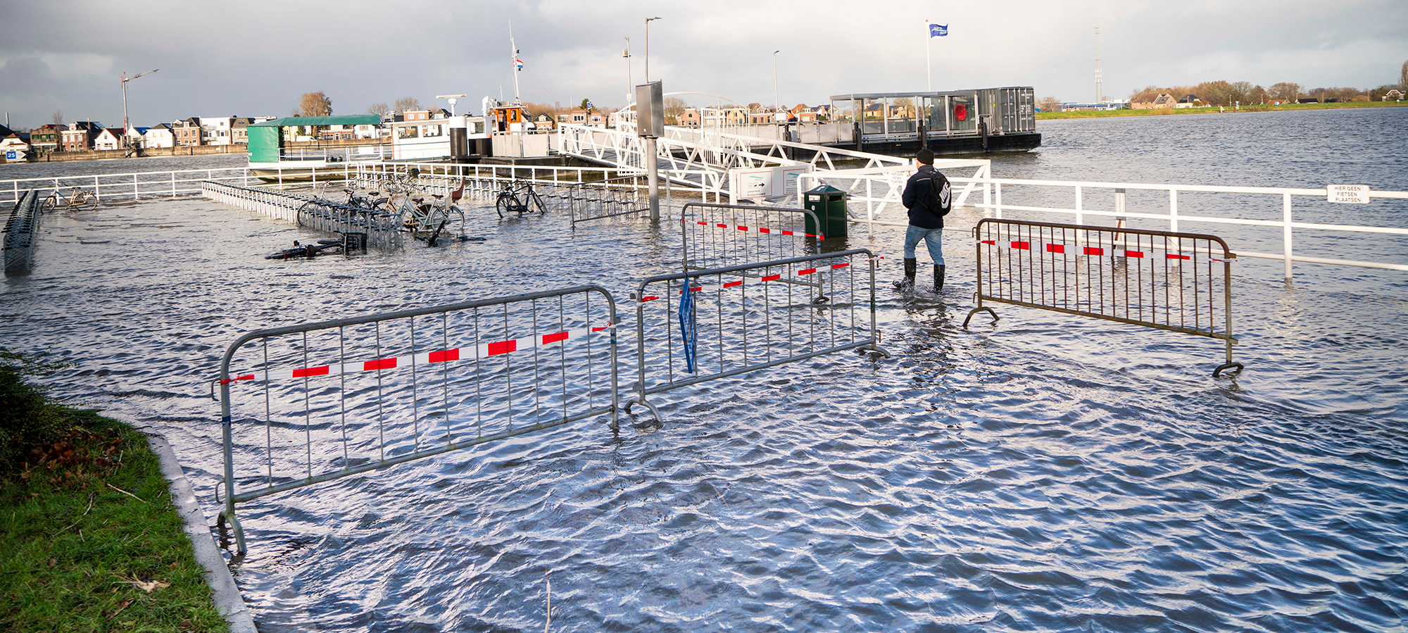Hekken voor het gesloten veer als gevolg van onder gelopen kade met water door hoog water