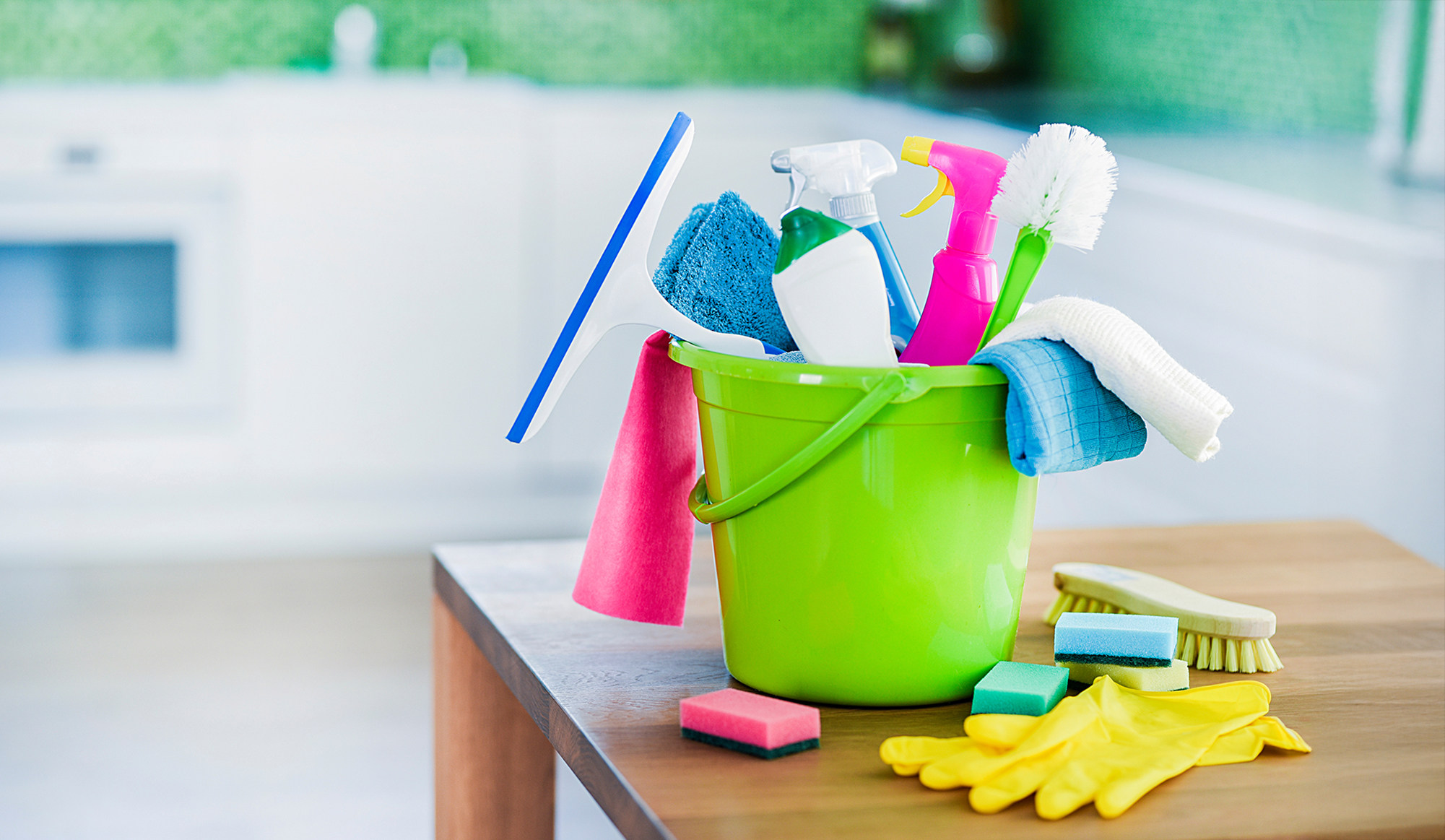 Biologische schoonmaakmiddelen in een groene emmer op tafel