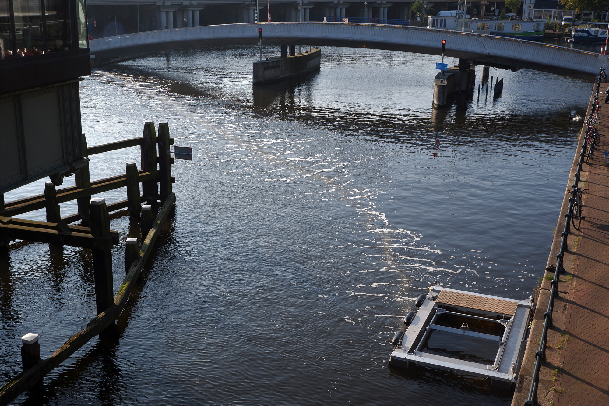Luchtbellen in de gracht van Amsterdam. Dat is de Bubble Barrier die afval in het water naar 1 hoe laat drijven. boven- en onderwater