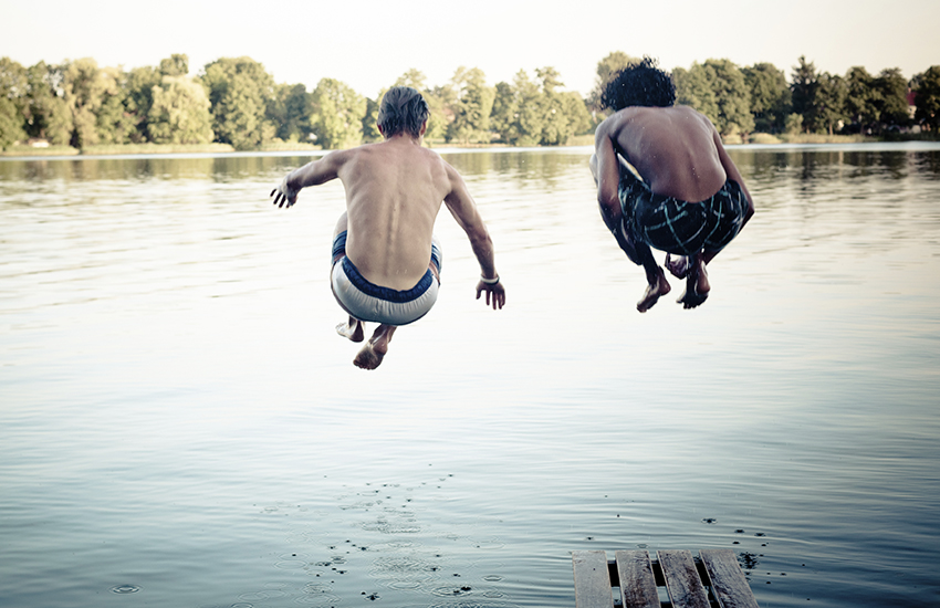 Jongens die in het water springen